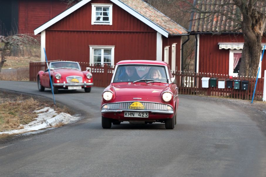 Röda engelska vagnar bland röda svenska stugor. Anglia och MGA.