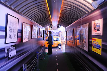 En tunnel fylld med reklambilder leder besökaren in i utställningen.