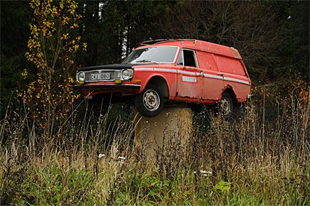 En Volvo 145 Express bektraktar tillvaron från en upphöjd position på Hällberga Bildemontering utanför Eskilstuna.