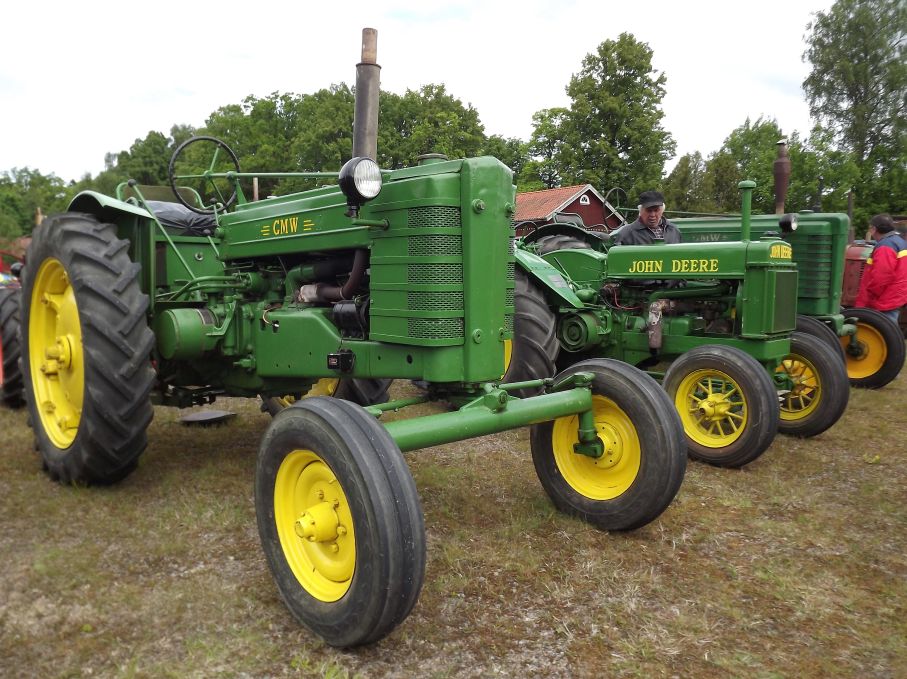 En John Deere model BR från 1939 står flankerad av två GMW-trakorer, GMW stod för Gnosjö mekaniska Werkstad även om dessa byggdes i Älmhult. Denna är från 1957.