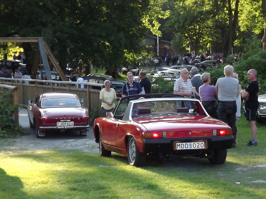 Volvo 1800S och Porsche 914 lämnar borggården över spången över vallgraven, där en gång fästningsmur och vindbrygga stod.