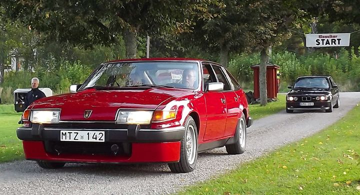 Skinande röd och ovanlig Rover 3500 Vitesse rullar in genom allén